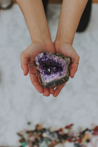 Woman holding amethyst mental health crystal in hand