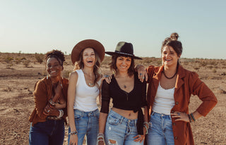 Four women standing in desert smiling to show self-empowerment through community